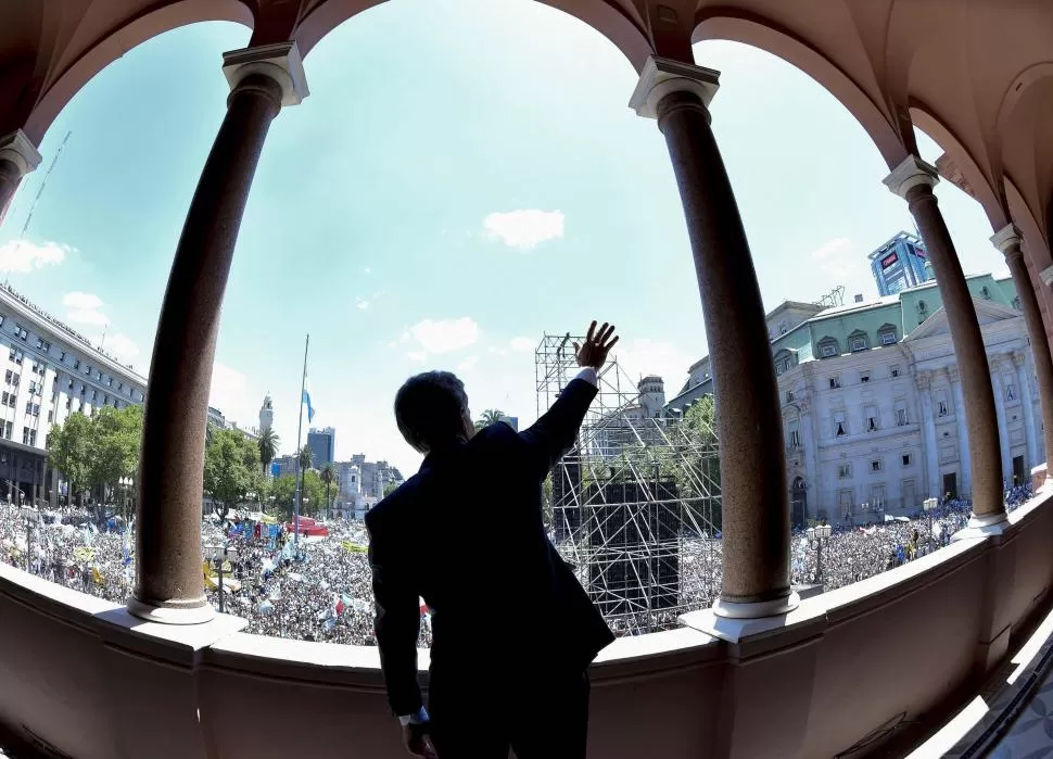 SALUDO PRESIDENCIAL. Desde el balcón de la Casa Rosada, Mauricio Macri extiende la mano derecha ante la multitud que estaba en la plaza de Mayo. telam