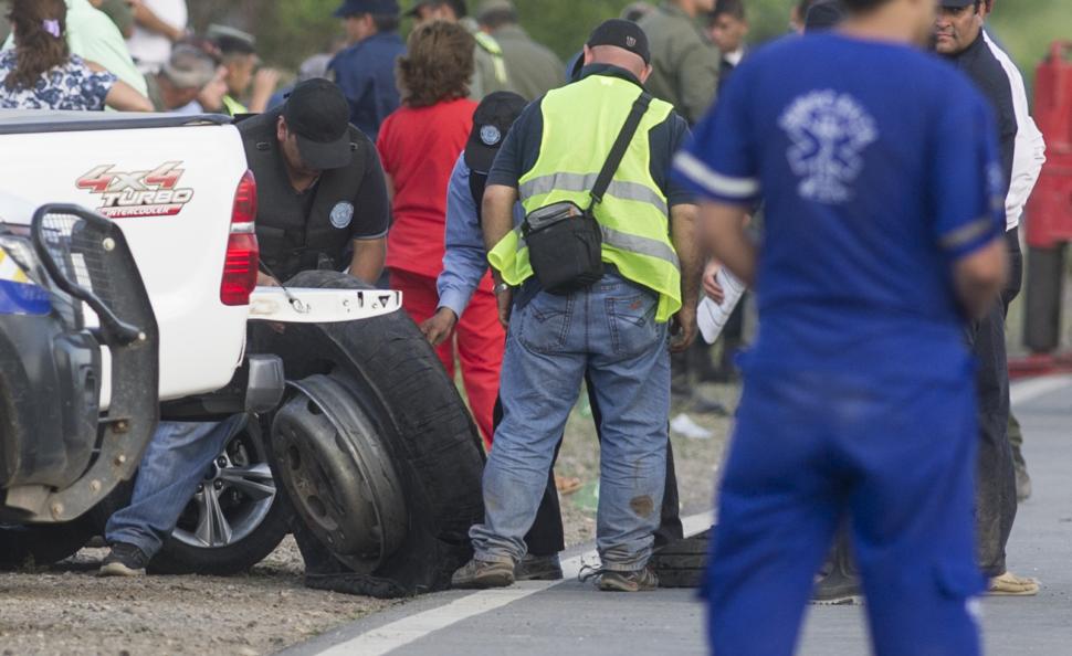 PERITAJE. Policías transportan el neumático que estalló y causó el accidente.  la gaceta / FOTO DE JORGE OLMOS SGROSSO