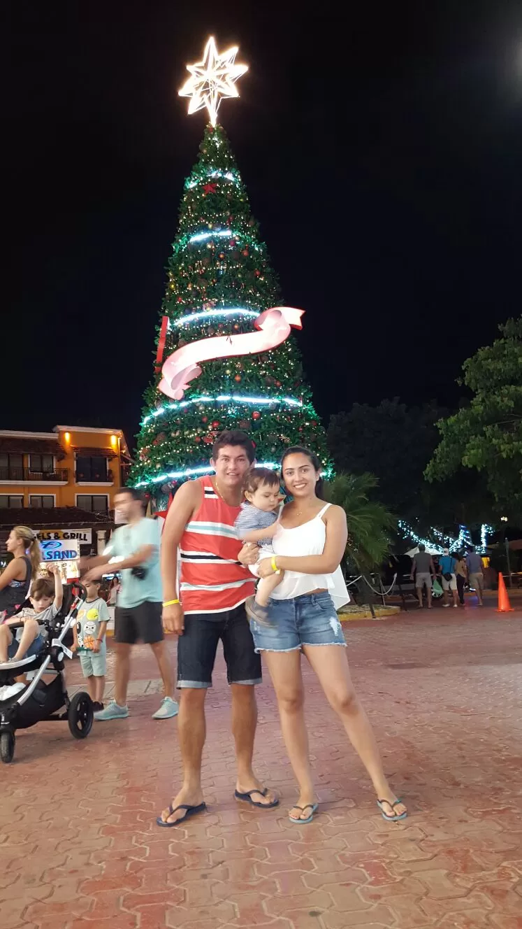 FELICES. Luis, Paola y Bautista en el árbol de Navidad del principal centro comercial de Playa del Carmen.  
