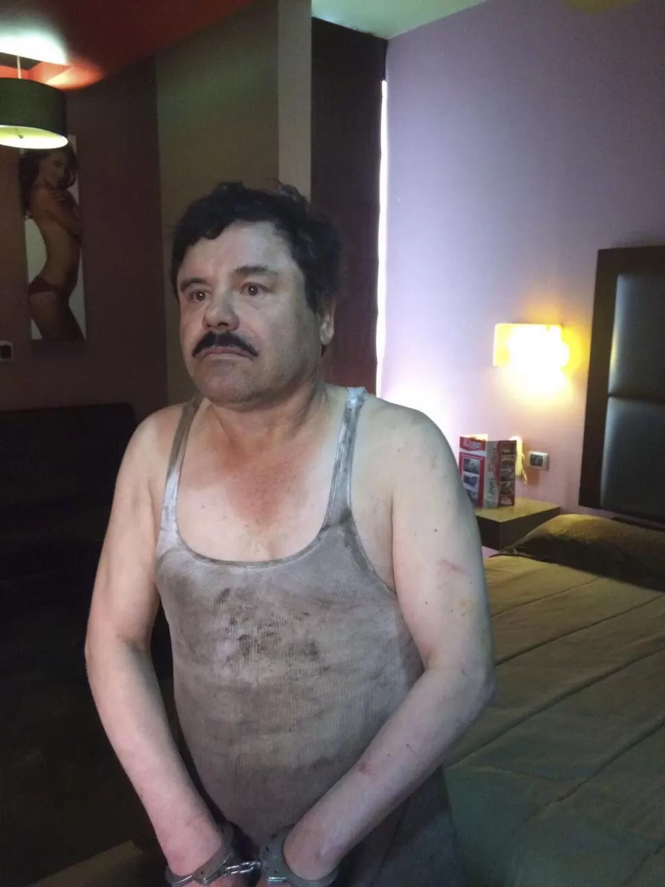 EN LOS MOCHIS. Guzmán, esposado y con la camiseta sucia, en la habitación del hotel donde se escondía. TÉLAM