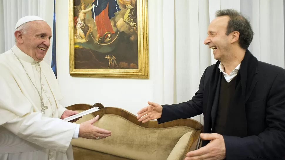 ENCUENTRO. Con el libro en la mano, el Papa saluda al actor  Robert Benigni. REUTERS