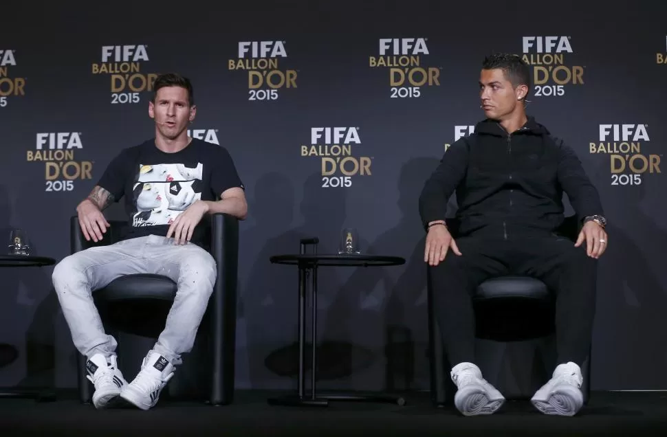 EN LA PREVIA. Messi contesta una pregunta durante la habitual conferencia de prensa que precede a la entrega del Balón de Oro. Cristiano mira atento a quien sería el ganador de la noche.  reuters