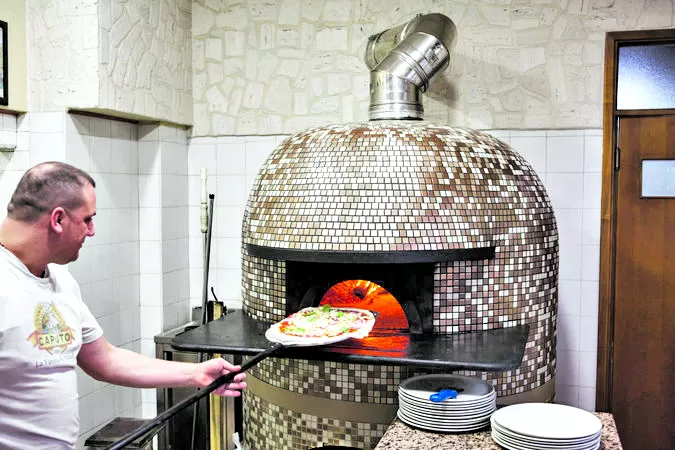 CONTAMINACIÓN. Gennaro Marano prepara una pizza en Il Cavallino. fotos Gianni Cipriano / The New York Times