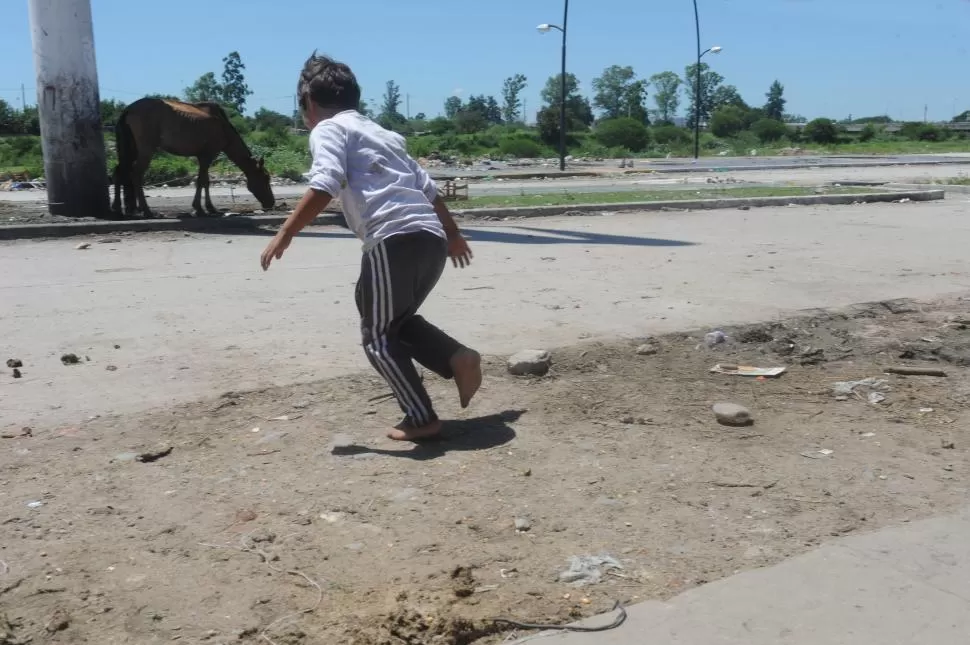 INDIGENCIA. Un chico corre sobre la tierra caliente del barrio La Costanera, donde reina la pobreza. la gaceta / foto de antonio ferroni 