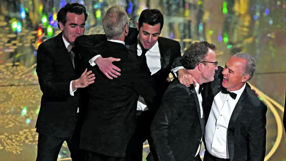 FESTEJANDO. El director y guionista Tom McCarthy (con el Oscar en su poder) se abraza con Michael Keaton, uno de los protagonistas de “En primera plana”, la gran victoriosa. REUTERS