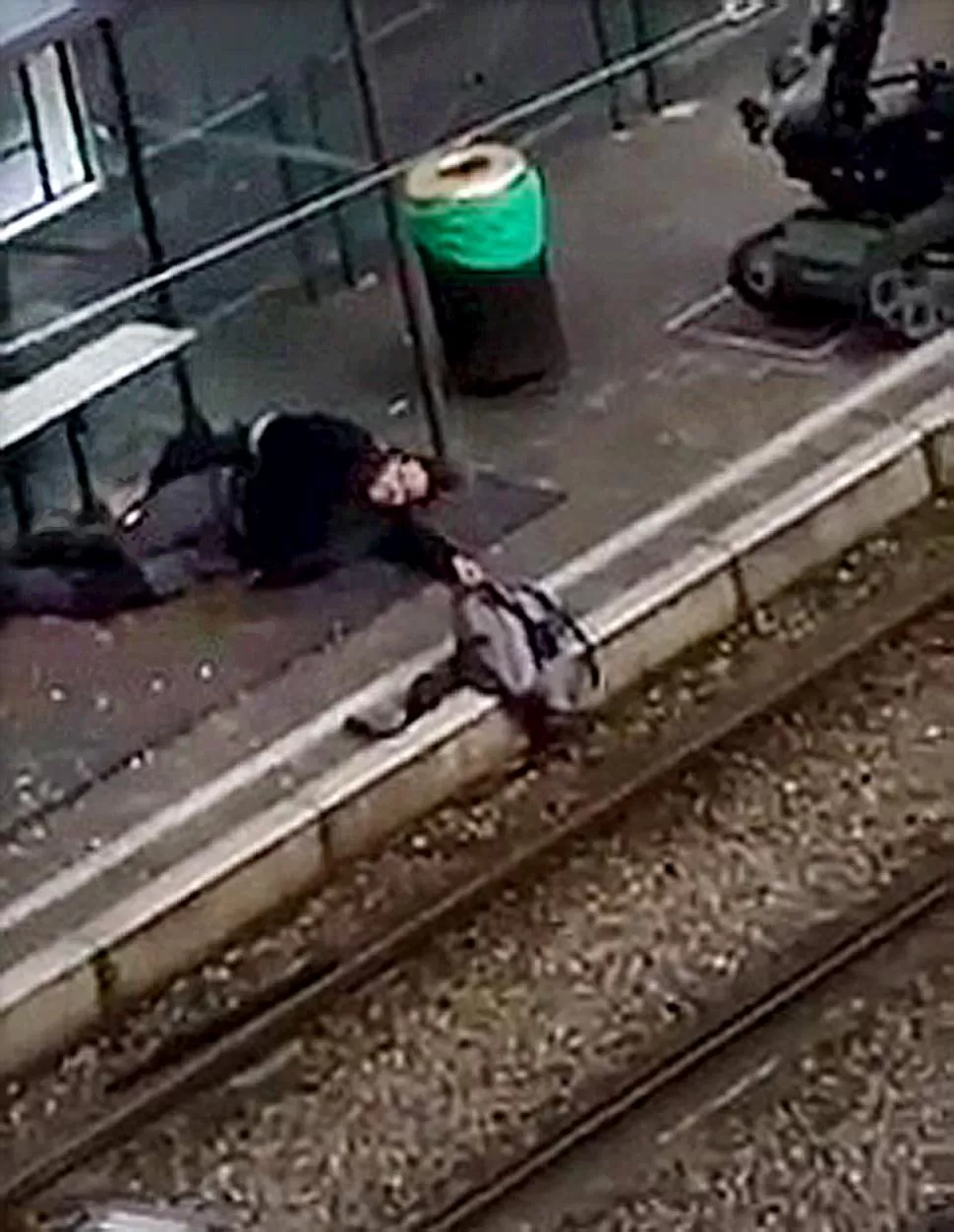 HUÍDA. Un sospechoso cae herido por la policía en la plataforma de una estación de tren de Schaerbeek. Reuters