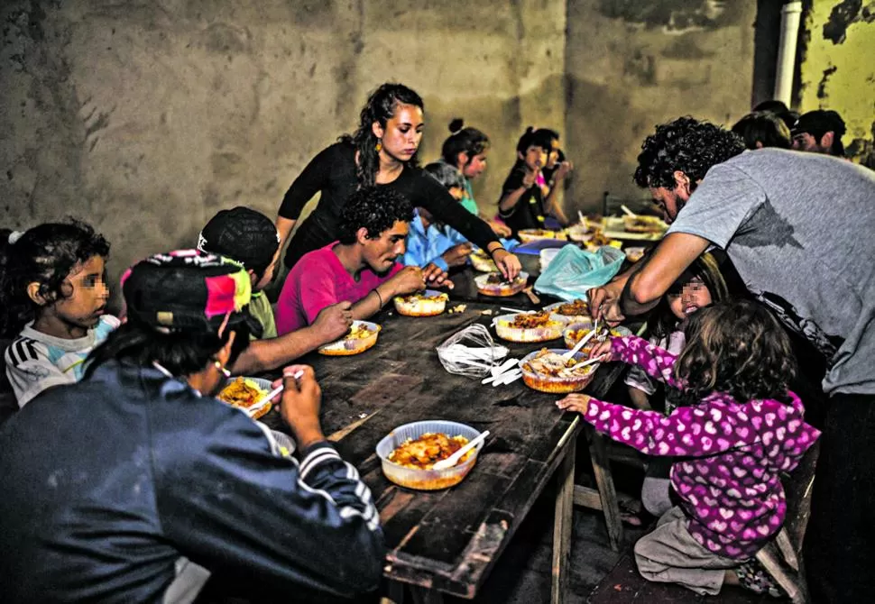 ESTOFADO SE ARROZ Y POLLO. Niños y jóvenes cenan en la Casa Parroquial de La Costanera, en la inauguración del comedor nocturno.  foto gentileza de Sebastian Lorenzo Pisarello