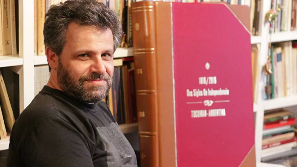 El dibujante Bernardo Erlich junto al libro del Bicentenario.