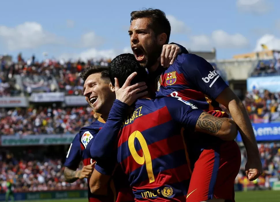 TODOS AL 9. Jordi Alba y Messi festejan con Suárez, autor de los tres goles con que Barça venció a Granada y campeonó. fotos de reuters