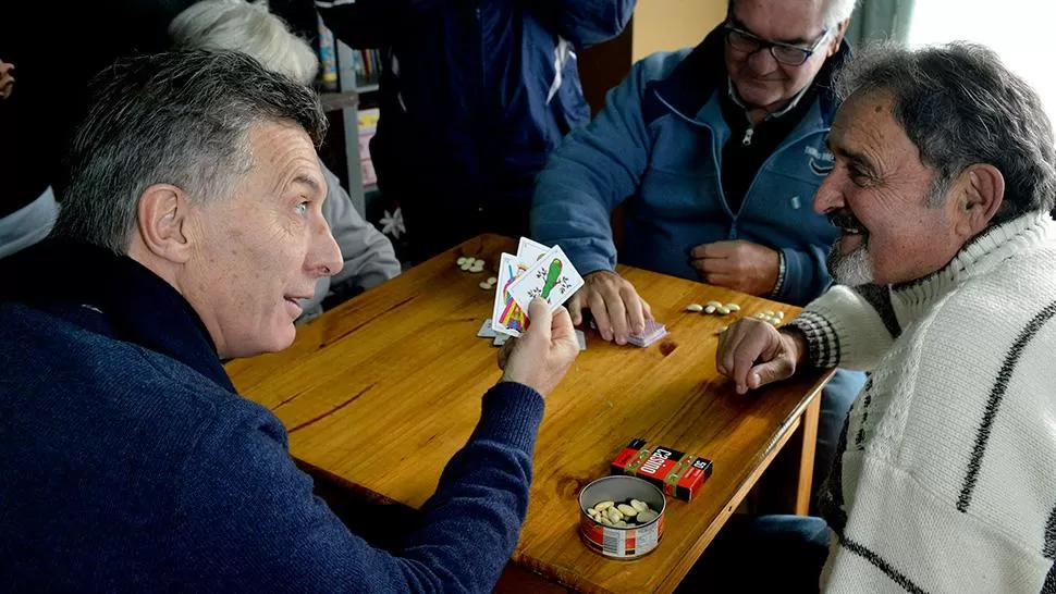 BUENA MANO. Macri le muestra a un jubilado las cartas que le tocaron. DYN