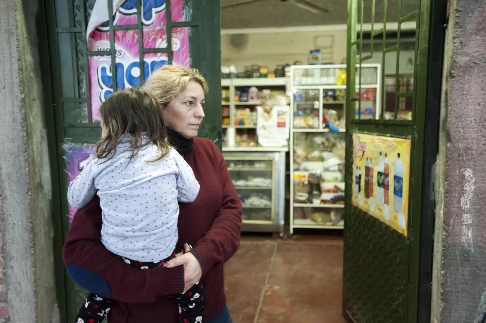 CON MIEDO. Espinoza, con su nieta en brazos en la puerta del negocio. la gaceta / foto de inés quinteros orio