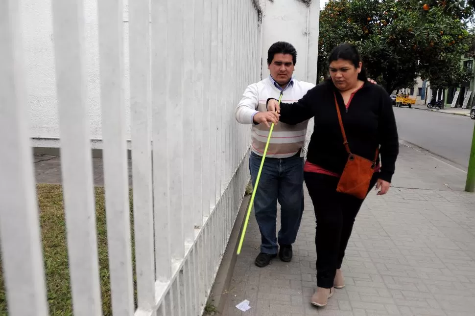 RECONOCIENDO LA CIUDAD. Vanina sale a caminar con su bastón verde; el profesor Miguel Campos le enseña técnicas para protegerse en la calle. LA GACETA / FOTOS DE ANALÍA JARAMILLO. 