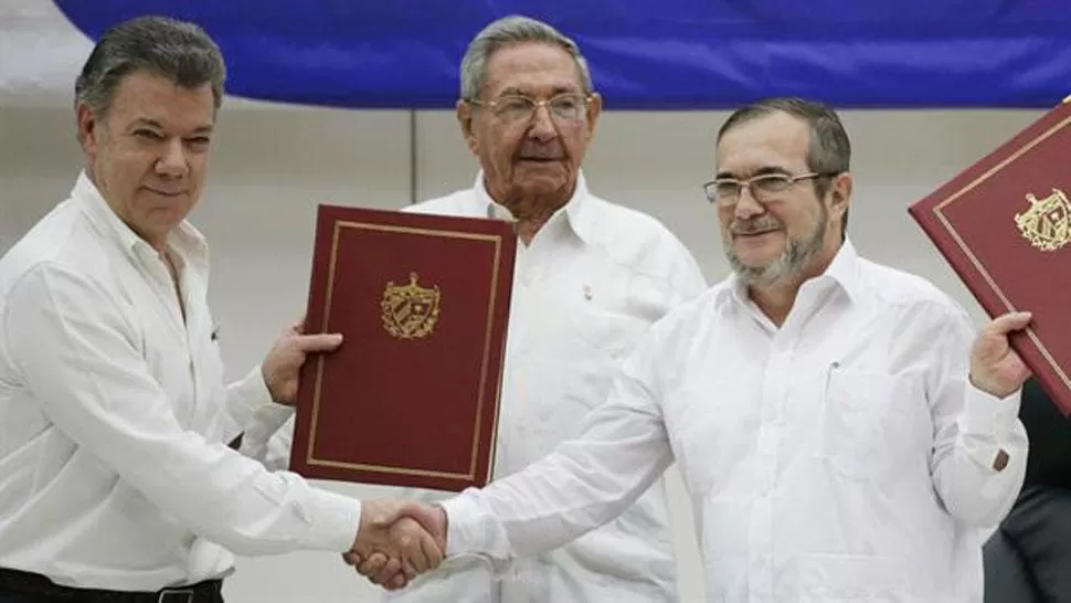 LA FOTO MÁS ESPERADA. Juan Manuel Santos y Rodrigo Londoño sellan el acuerdo con la observación de Raúl Castro.  FOTO TOMADA DE LANACION.COM.AR