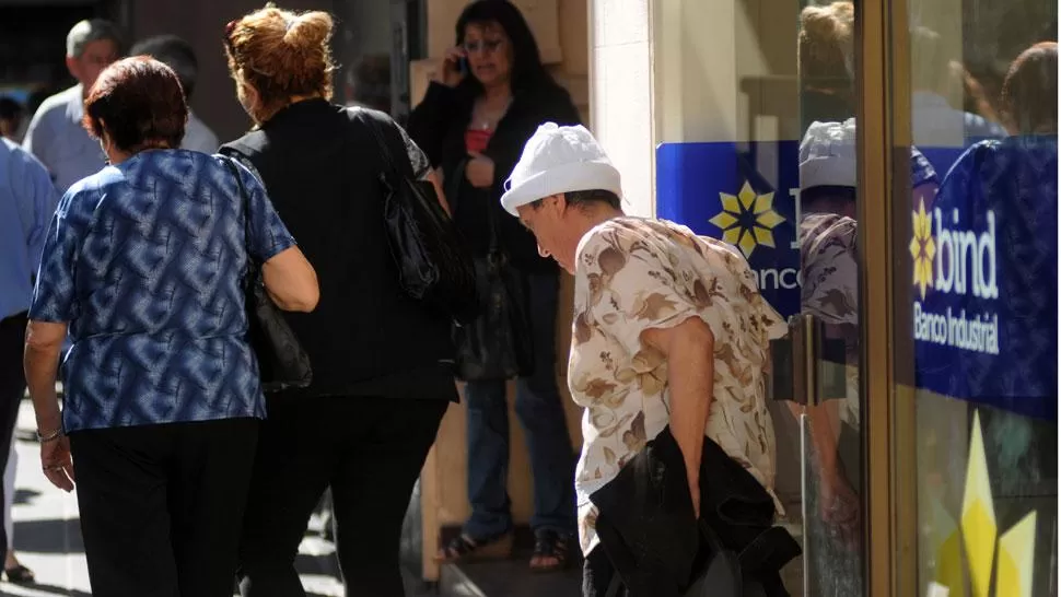 JUBILADOS. Tres mujeres mayores salen de un banco en la city tucumana. ARCHIVO