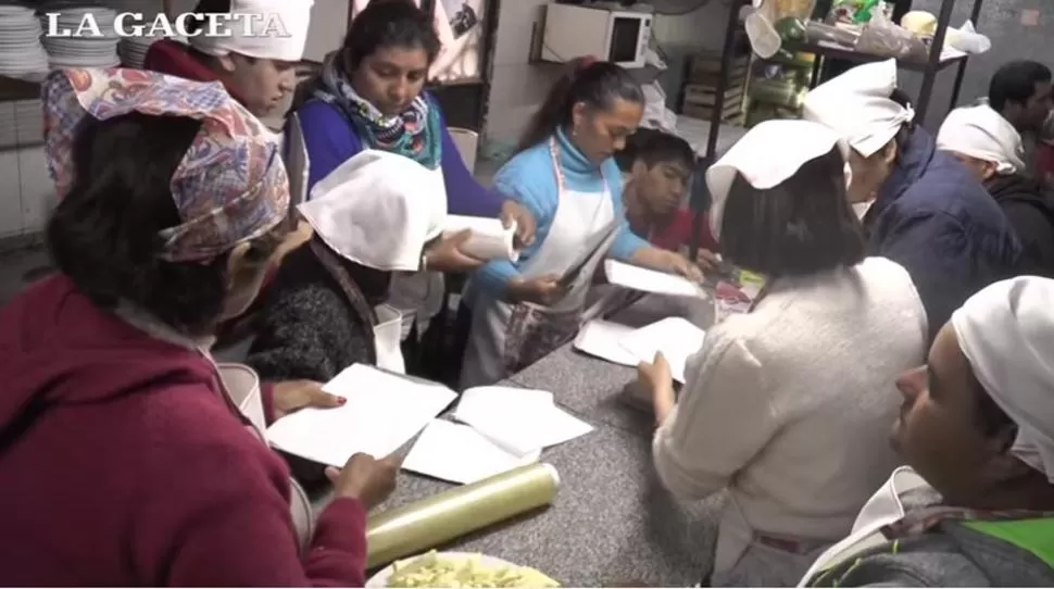 Alumnos del Centro de Día Despertar cocinan para la heladera social. FOTO CAPTURA DE VIDEO.
