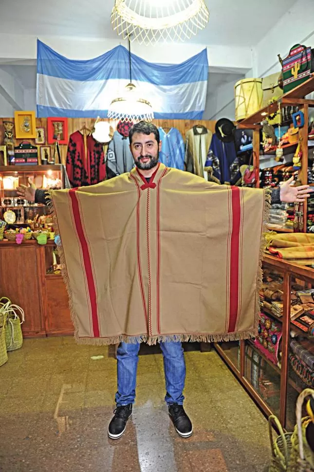 UNA DE LAS DOS VERSIONES. Julio Correa, de un negocio de regionales, muestra el poncho industrial, más liviano y más barato que el artesanal. la gaceta / foto de franco vera