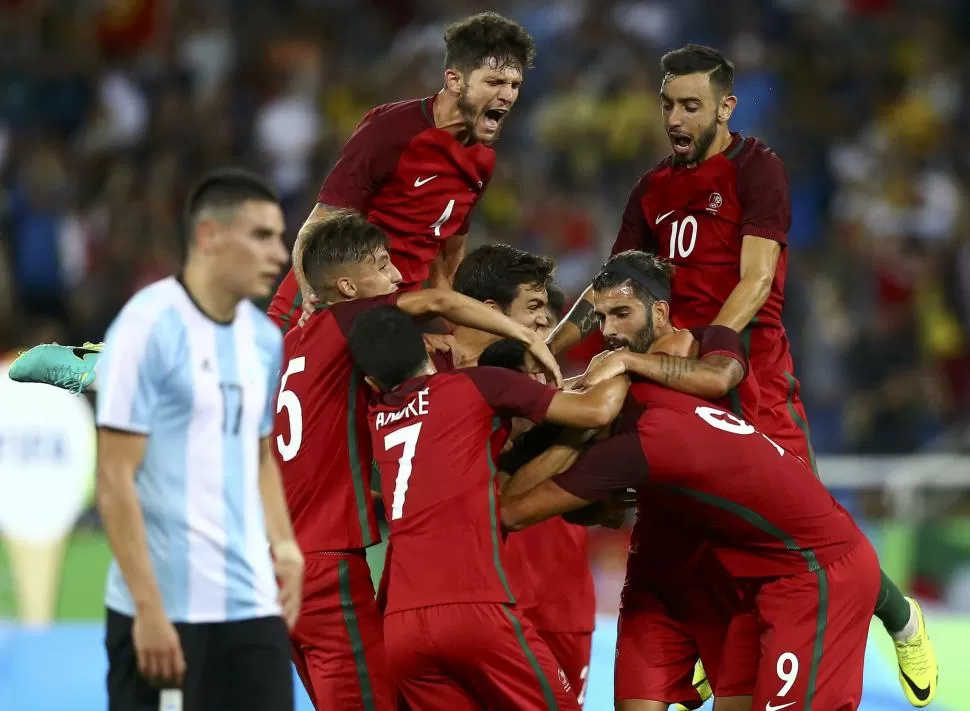 TODO MAL. Mauricio Martínez sufre mientras los jugadores de Portugal festejan un triunfo que no estaba en los planes. reuters
