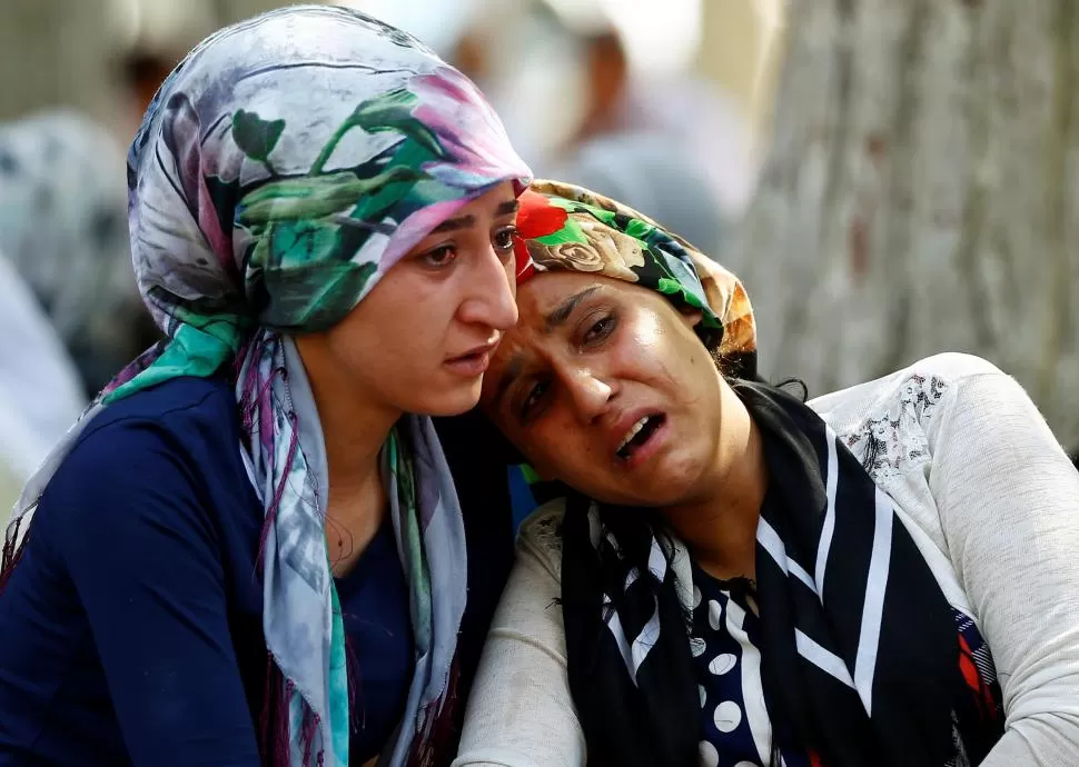 DOLOR SIN LÍMITE. Dos mujeres lloran a uno de los muertos en la fiesta de casamiento a la que asistían en Gaziantep, un pueblo al sur de Turquía. fotos reuters 