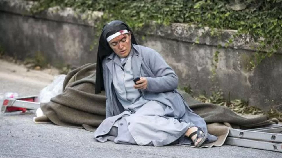 POSTAL. Una religiosa ensangrentada en el suelo, una de las imágenes que simbolizan la devastación causada por el mortal terremoto que asoló a Italia el 24 de agosto de 2016.