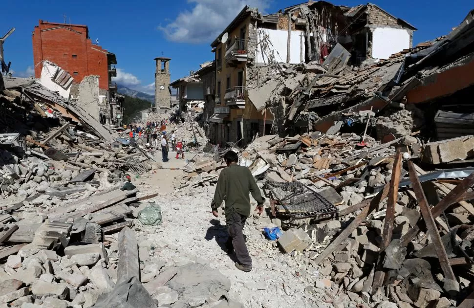 DAÑOS Y DESOLACIÓN. Un hombre camina entre los escombros en Pescara del Tronto, tratando de ayudar a los grupos de rescate que buscan a pobladores entre los escombros. fotos reuters 