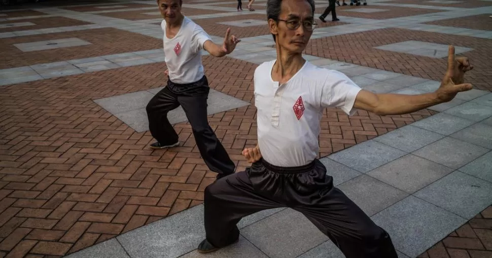 EN EL PARQUE. Mak Che Kong, maestro de kung fu, imparte una clase en Kowloon, Hong Kong. Cerró su academia cuando aumentó el alquiler. Lam Yik Fei / The New York Times