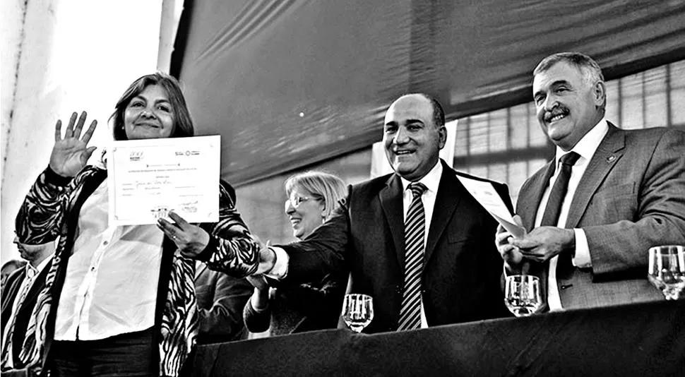 EN LA USINA DEL BICENTENARIO. Manzur entrega un certificado a una de las beneficiarias en acto del que participaron el vicegobernador Jaldo y la rectora de la UNT Alicia Bardón (de anteojos). comunicaciontucuman.gob.ar