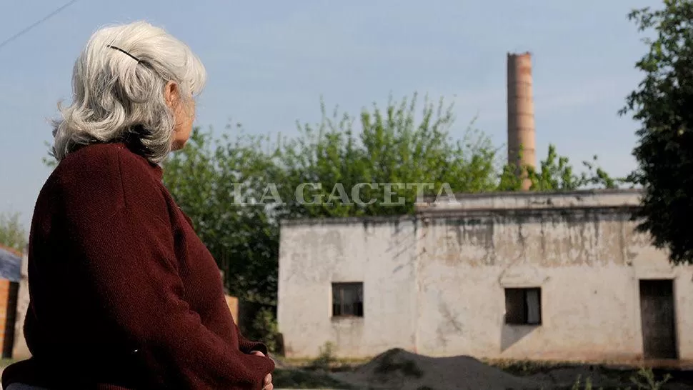 AÑORANZA. Eugenia Giménez, hija de un ex obrero del ingenio, mira la chimenea, lo único que quedó en pie.  LA GACETA / FOTOS DE ANALÍA JARAMILLO