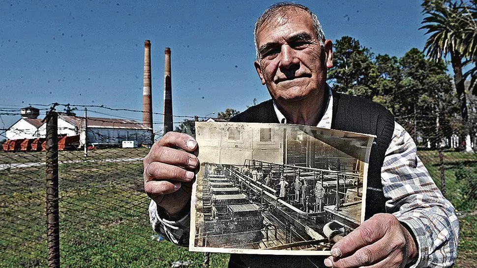 DESTINO. Martín Pedraza posa junto a los restos del ingenio con una foto que lo muestra en su mejor momento. LA GACETA / FOTOS DE FRANCO VERA
