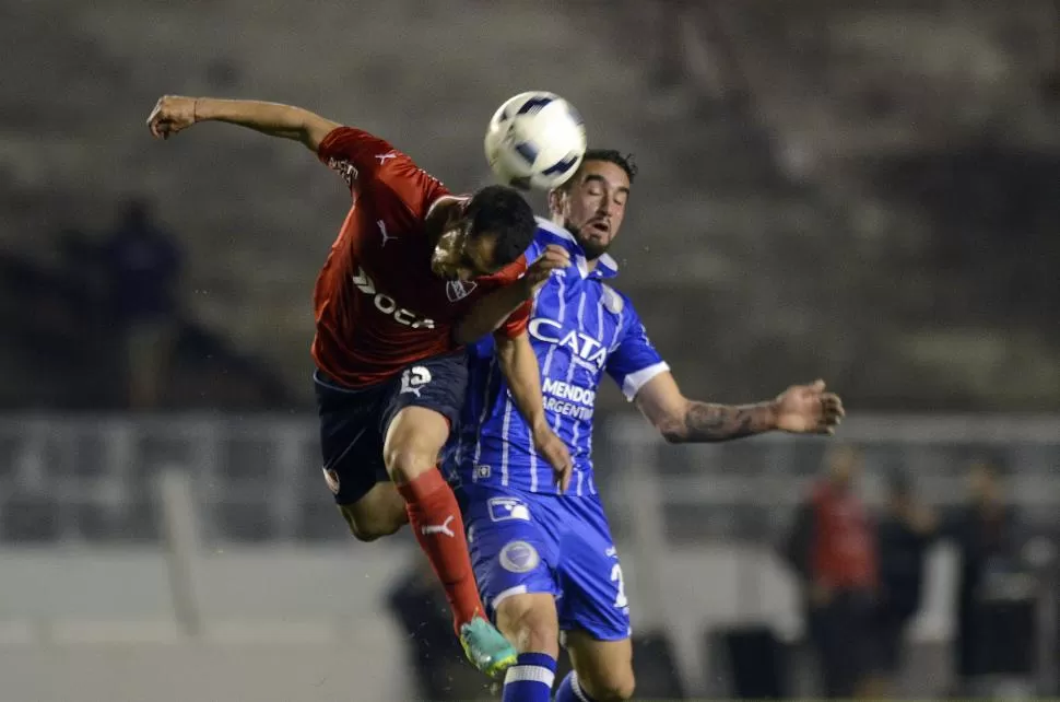 LUCHA AÉREA. Rodríguez Berrini, de Independiente, supera con un cabezazo a Sigales, de Godoy Cruz, en el primer tiempo. Dyn