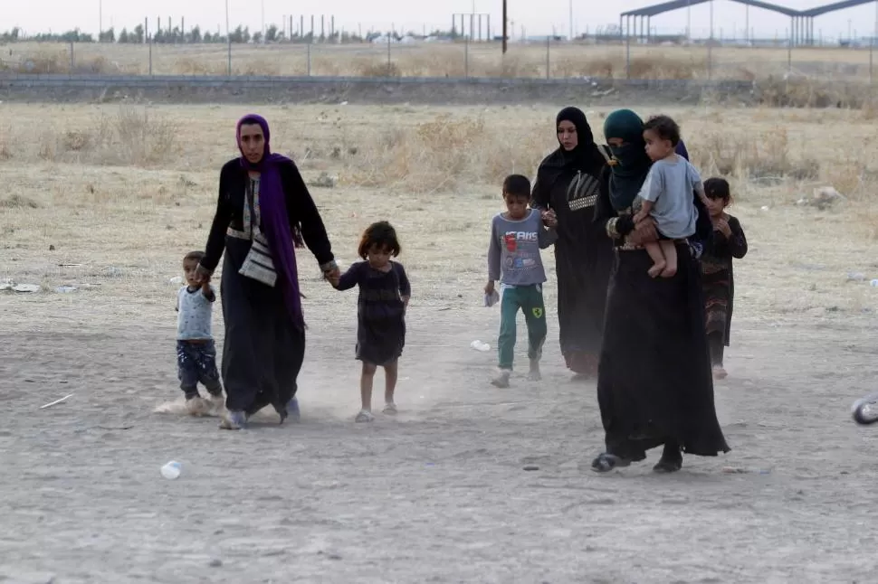 REFUGIADOS. Mujeres y niños irakíes huyen de la guerra en Siria. reuters