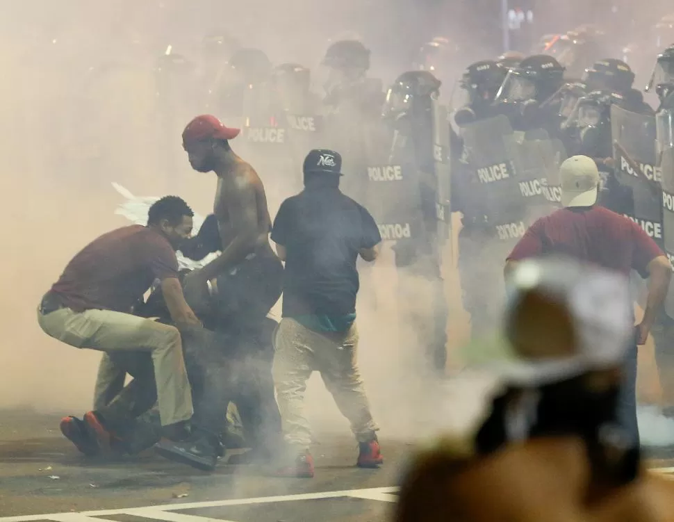 CHARLOTTE. Manifestantes negros se encaran con la policía, que los repelió lanzándoles gases lacrimógenos. reuters