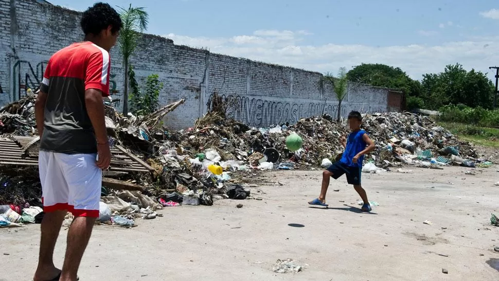 POBREZA. Dos niños juegan al fútbol junto a un basural en un barrio pobre de Tucumán. ARCHIVO