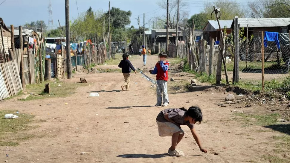 POBREZA. Tres niños en un asentamiento del Gran San Miguel de Tucumán. ARCHIVO
