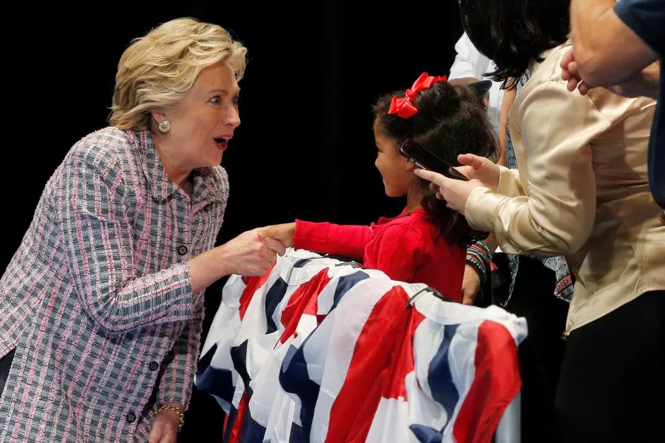 FUTURA VOTANTE. Hillary saluda a Caylin Riggins, de seis años, en Fort Pierce reuters