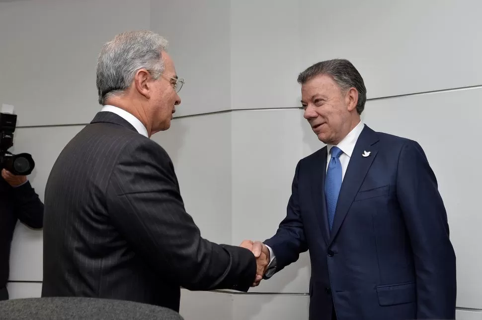 PARA QUE HAYA PAZ. Uribe y Santos se encontraron y saludaron después de seis años de duros enfrentamientos. reuters 