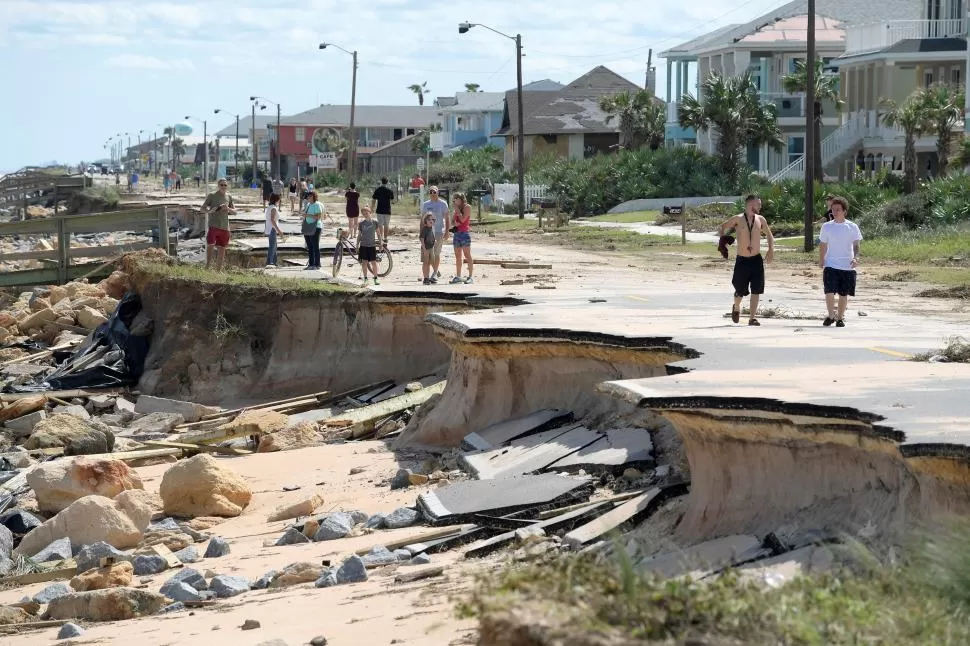 FLAGER BEACH, FLORIDA. Vecinos de esta ciudad costera estadounidense caminan entre lo que fue la carretera estatal A1A, destruida por el huracán. reuters