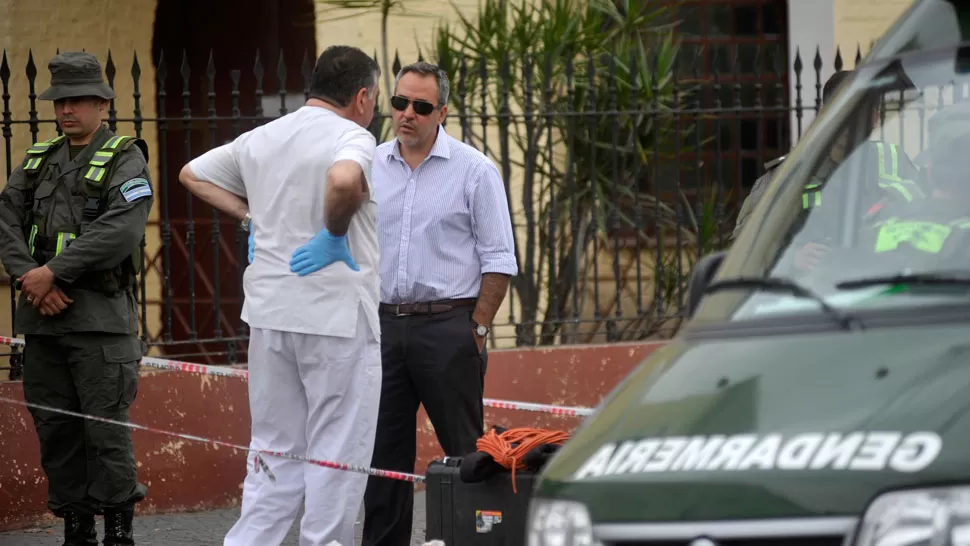 EN LA FLORIDA. López Ávila habla con un perito de Gendarmería en la puerta de la iglesia en la que murió Viroche. LA GACETA / INÉS QUINTEROS ORIO