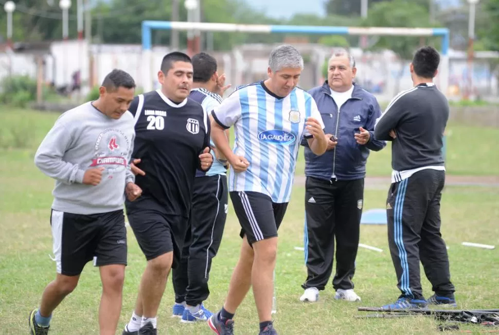 EN LA CANCHA. Raúl Serrano (con camiseta celeste y blanca) lidera el trote alrededor de la cancha de fútbol. la gaceta / foto de héctor peralta