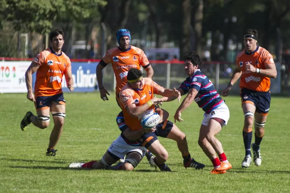 ABAJO. Mariano Sánchez intenta mantener el control frente al tackle de un rival. Los “Naranjas” acusaron el desgaste físico del Regional y no supieron liquidar a Cuyo. la gaceta / foto de jorge olmos sgrosso