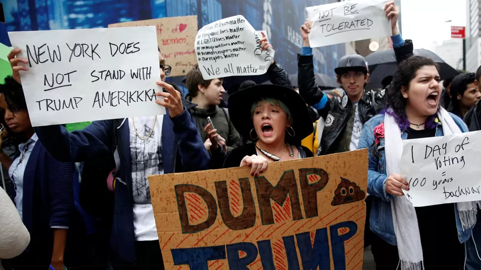 BRONCA. Nueva York no apoya a Trump, dicen los carteles de manifestantes en Times Square. REUTERS