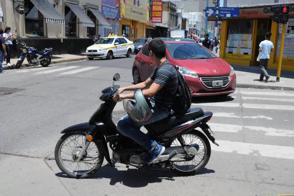 EN INFRACCIÓN. Una imagen que, lamentablemente, se ve con demasiada frecuencia en las calles tucumanas: el casco en el codo y no en la cabeza. LA GACETA / FOTO DE ANALÍA JARAMILLO-.