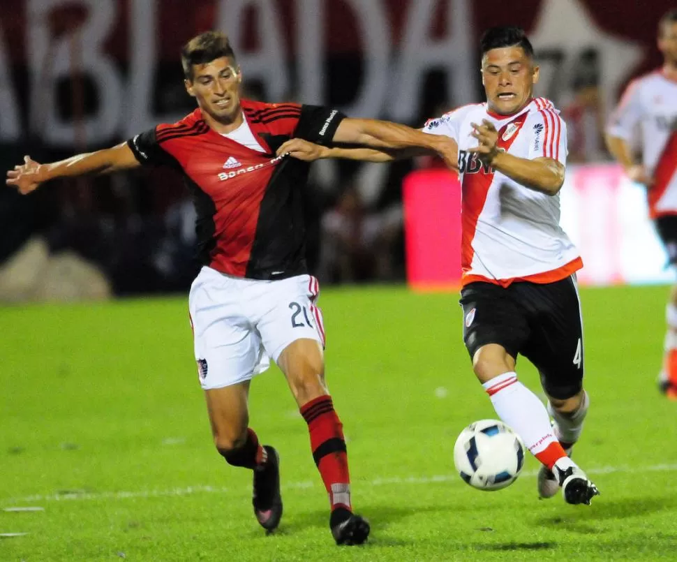 CON LOS DIENTES APRETADOS. Joel Sills y Jorge Moreira luchan por la pelota en un partido en el que la “Lepra” sacó ventaja. telam 