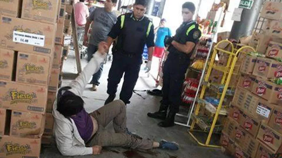 HERIDO. Un policía sostiene al hombre herido. FOTO ENVIADA POR FACEBOOK