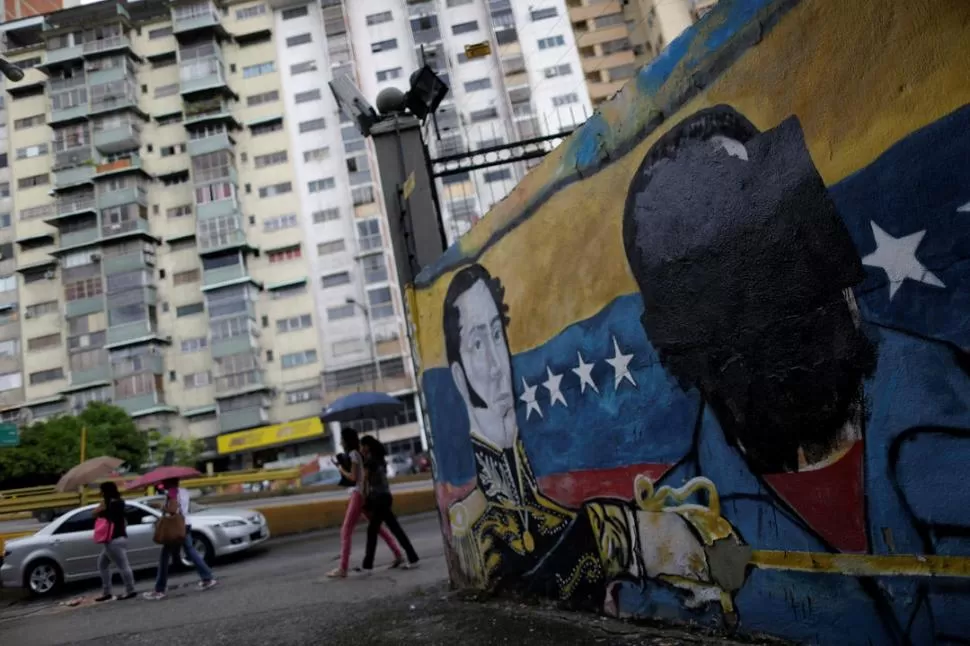 MALESTAR POPULAR. Un mural pintado con las imágenes de Bolívar y Maduro fue repintado de color negro sobre el rostro del Presidente. Reuters