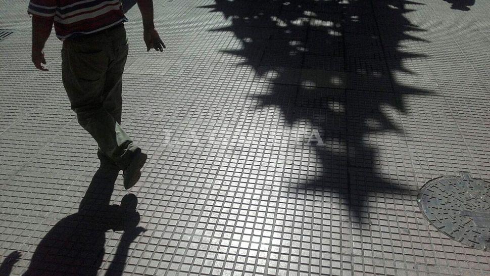 DOMINGO CALIENTE. Un hombre camina por la peatonal mientras se proyecta la sombra del árbol de Navidad de Mendoza y Muñecas. LA GACETA / FOTO DE DIEGO ARÁOZ