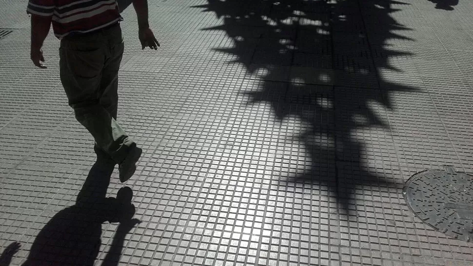 DOMINGO CALIENTE. Un hombre camina por la peatonal mientras se proyecta la sombra del árbol de Navidad de Mendoza y Muñecas. LA GACETA / FOTO DE DIEGO ARÁOZ