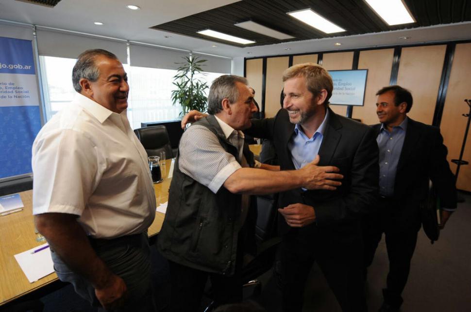 EL ABRAZO DEL ACUERDO. Juan Carlos Schmid y Héctor Daer, saludan a Rogelio Frigerio tras la reunión de ayer. dyn