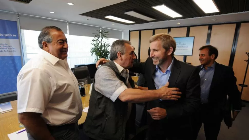 EL ABRAZO DEL ACUERDO. Juan Carlos Schmid y Héctor Daer, saludan a Rogelio Frigerio tras la reunión de ayer. dyn
