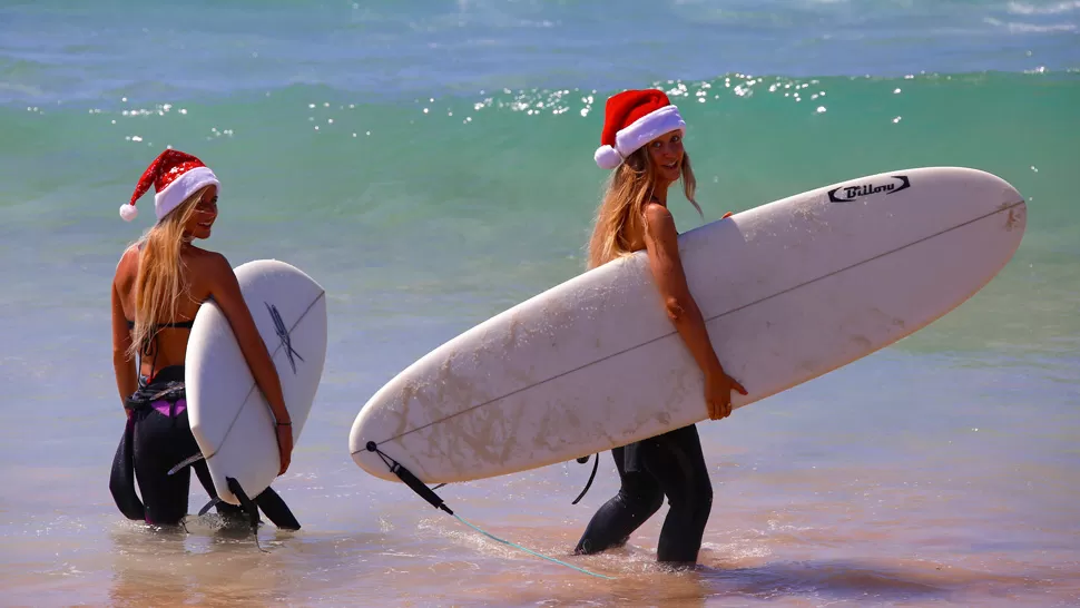 AL SOL. Dos turistas alemanas disfrutan de Bondi Beach, en Sidney, Australia. REUTERS
