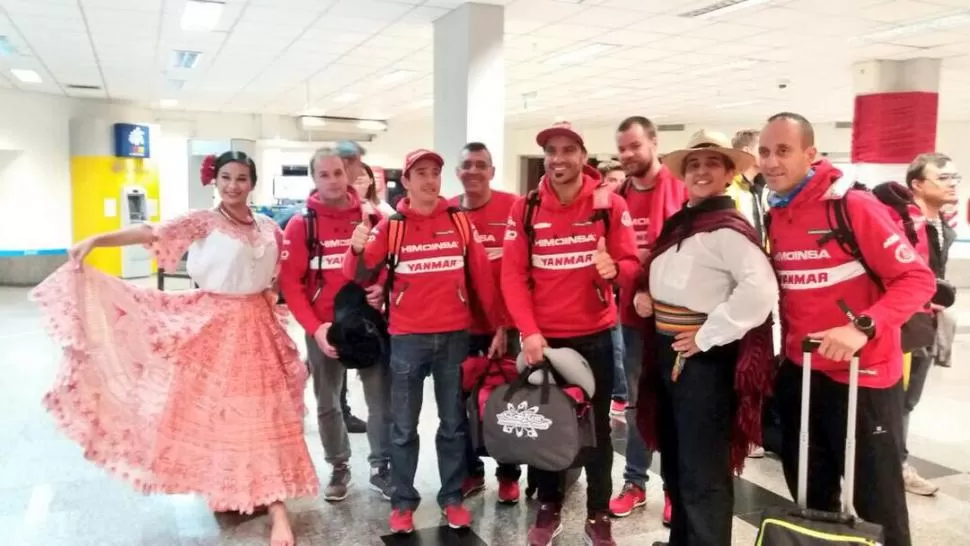 BIENVENIDA. Una dama recibió a pilotos e integrantes de los equipos que pudieron apreciar el traje típico llamado typói. twitter @Senatur_Py